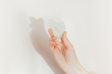 Hand holding stone massager against white background.