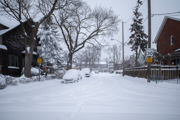 Toronto, Ontario / Canada - January 17, 2022 - Toronto St Clair West sideroad with cars covered on day of snowstorm
