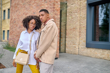 Young stylish man and woman looking at camera