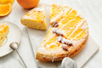Tasty citrus cake with oranges on table