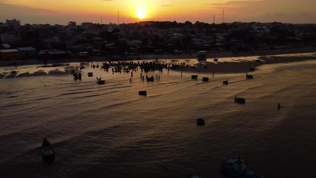 Local Vietnamese sorting seafood catch for distribution in early morning, aerial drone shot