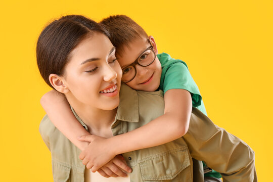 Teenage Girl Carrying Backapack Her Little Brother On Yellow Background