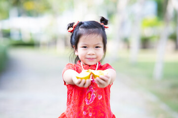Happy child holding golden coin in ancient China wishing wealth, little kid girl two hands held money in front of her.