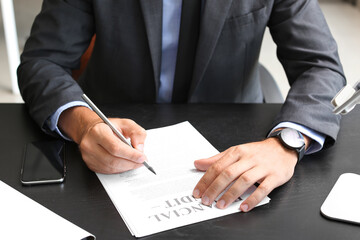 Young businessman working with document at table in office, closeup