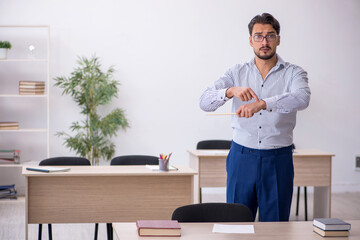 Young male teacher in time management concept