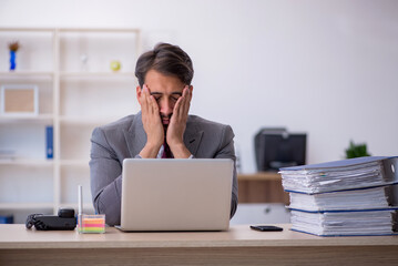 Fototapeta premium Young male employee working in the office