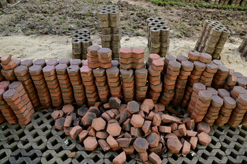 Close-up of Pile of worm block bricks prepared for pavement pattern texture background in the park at Thailand.