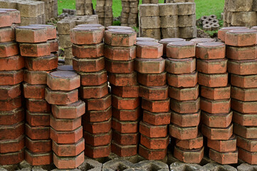 Close-up of Pile of worm block bricks prepared for pavement pattern texture background in the park at Thailand.