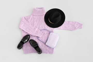 Knitted sweater, felt hat, bag and shoes on light background