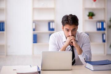 Fototapeta premium Young male employee working in the office