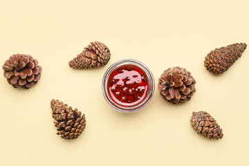 Jar of tasty pine cone jam on beige background
