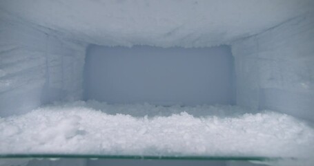 Empty household freezer full on ice to be melted, dolly forward shot
