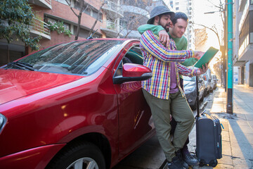 A latin gay tourist couple on a red car looking for directions in the city to celebrate a romantic...
