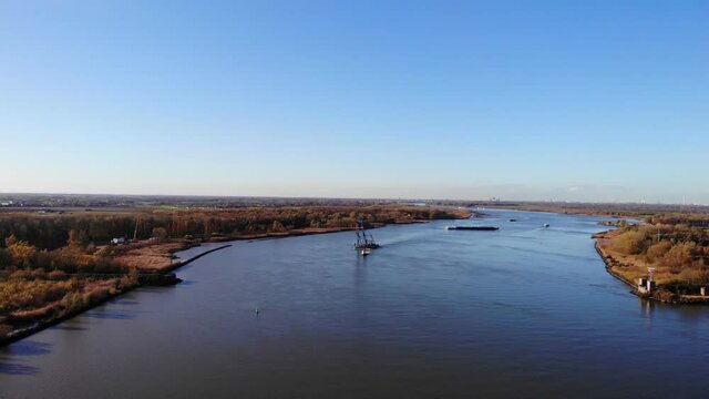 Towboat Pulling Floating Crane Across The River In Barendrecht, Netherlands. wide aerial