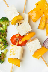 Plate with grilled tofu cheese skewers, closeup