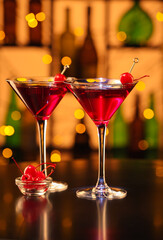 Glasses of tasty Manhattan cocktail on table in bar