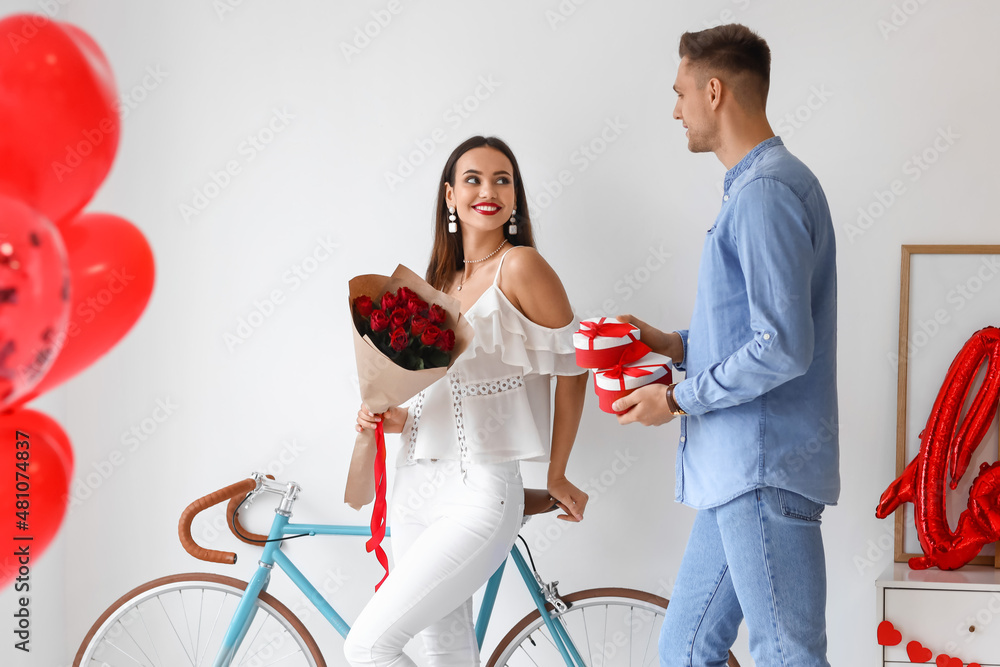 Wall mural Young man greeting his girlfriend for Valentine's Day at home