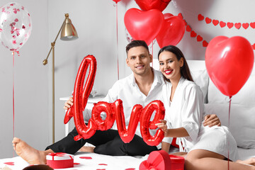 Beautiful young couple celebrating Valentine's Day at home - obrazy, fototapety, plakaty