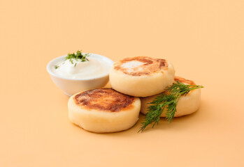 Tasty cottage cheese pancakes and sauce on beige background