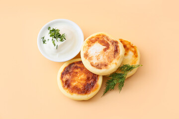 Tasty cottage cheese pancakes and sauce on beige background