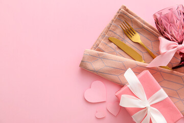 Beautiful cutlery, gift box and hearts on pink background
