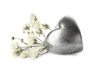 Tasty heart-shaped candy and flowers on white background