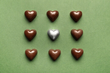 Obraz premium Tasty heart-shaped candies on green background