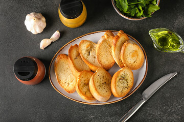 Plate of tasty croutons on black background
