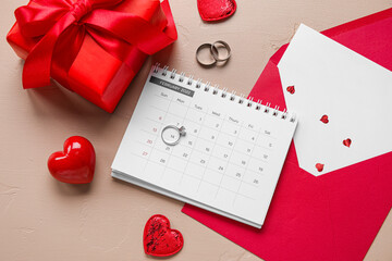 Calendar with rings, envelope, gift and hearts on beige background. Valentine's Day celebration