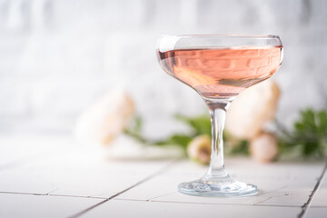 Pink champagne or cocktail in a glass on white background
