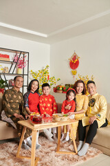 Big family gathered at home to have tea with sweets and candied fruits for Chinese New Year