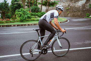 Fototapeta premium male riding a road bike in beautiful country road