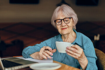 Portrait of an elderly woman documents work sheet of paper and pen Retired woman chatting unaltered