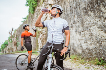 Fototapeta na wymiar road bike cyclist take a brake and drink a bottle of water
