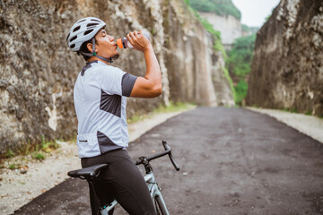 road bike cyclist take a brake and drink a bottle of water