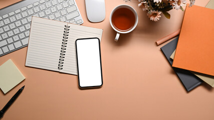 Mockup smart phone, notebooks, coffee cup and keyboard on beige background.