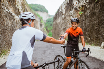 road bike cyclist take a brake and drink a bottle of water