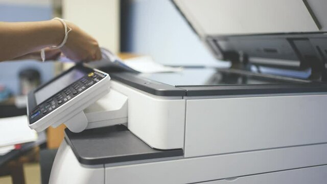 Hand of woman is using a photocopier to copy documents.