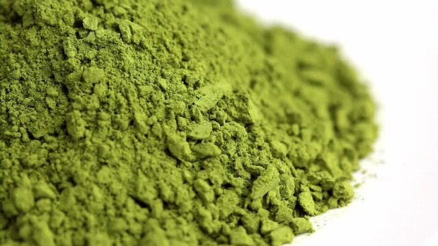 Matcha green tea powder rotating on white background.