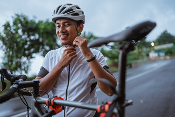 Young man cyclist wearing his sports helmet outdoor