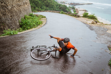 Exhausted cyclist fell down on the road