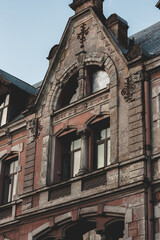 Fototapeta na wymiar Old Art Nouveau building with wall decor. Red house wall on a sunny day. Riga, Latvia, January 2022