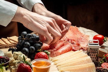 Woman holding Italian prosciutto crudo or spanish jamon. Delicious appetiser Italian prosciutto and Spanish Iberian ham snack