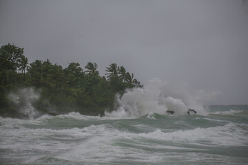 sea spray and surf on rocks in a storm with high waves on tropical cyclone