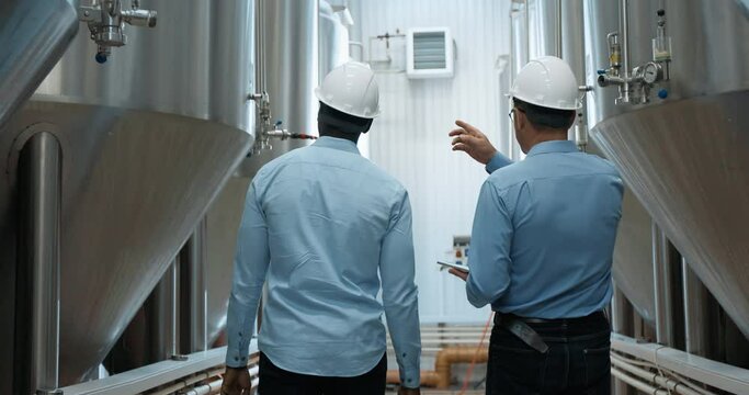 Two Industry Engineers Walk in Factory, Use Tablet and Discuss Work