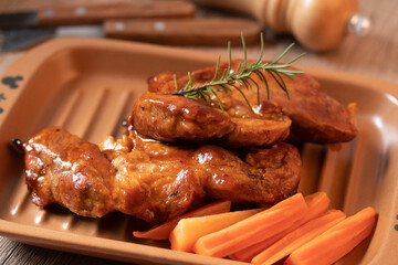 Meat during grilling. Chuck steak and rosemary garnished carrots.