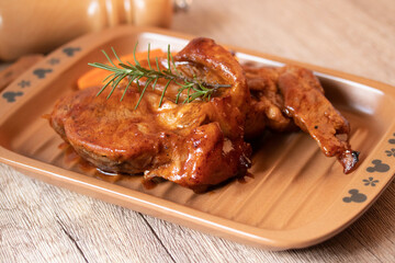 Meat during grilling. Chuck steak and rosemary garnished carrots.