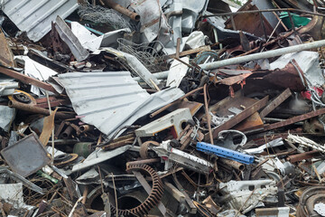 Pile of scrap rusty metal waste on recycling yard. Disposal and secondary metal recycling.