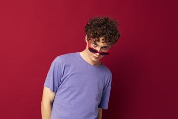 cute red-haired guy hand gestures heart shaped glasses posing red background