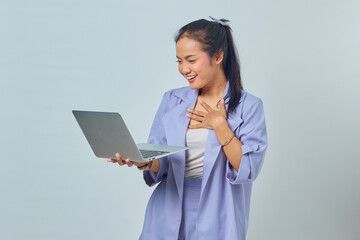 Portrait of excited young Asian woman receiving project emailed on laptop isolated on white background